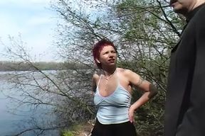 Redhead German lady gets her mouth filled near the lake