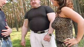 A sexy brunette German slut enjoys pleasing two hard cocks outdoors